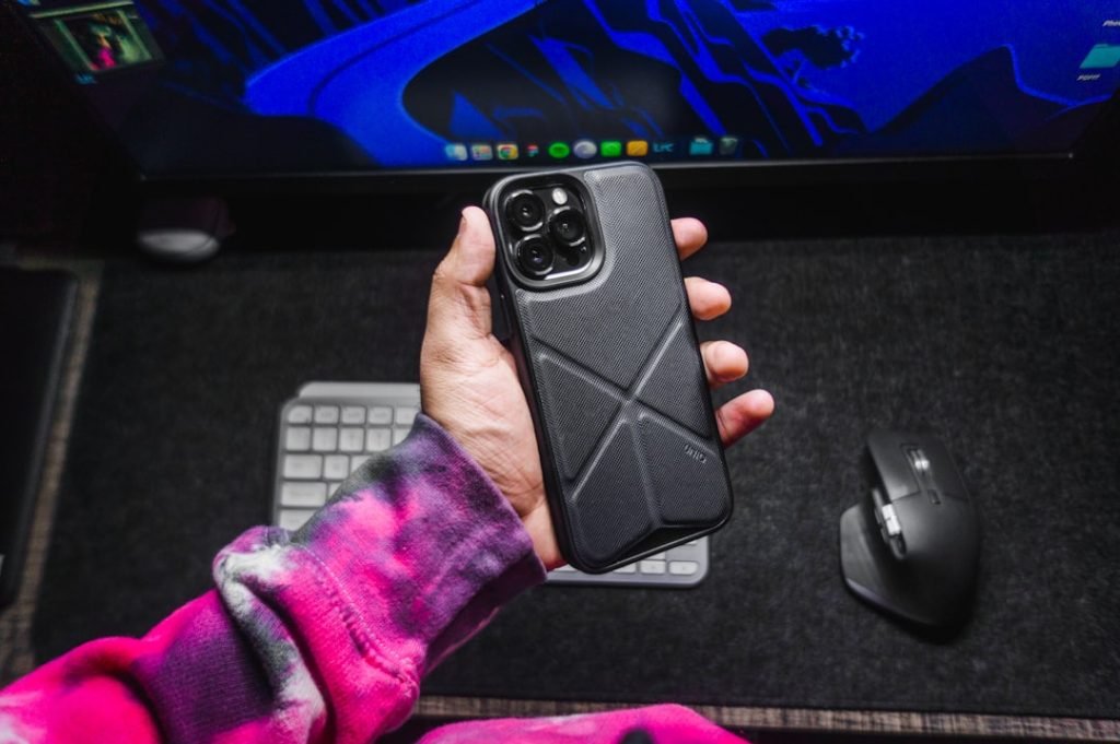 Guy holding iPhone 13 Pro Max with UNIQ Case